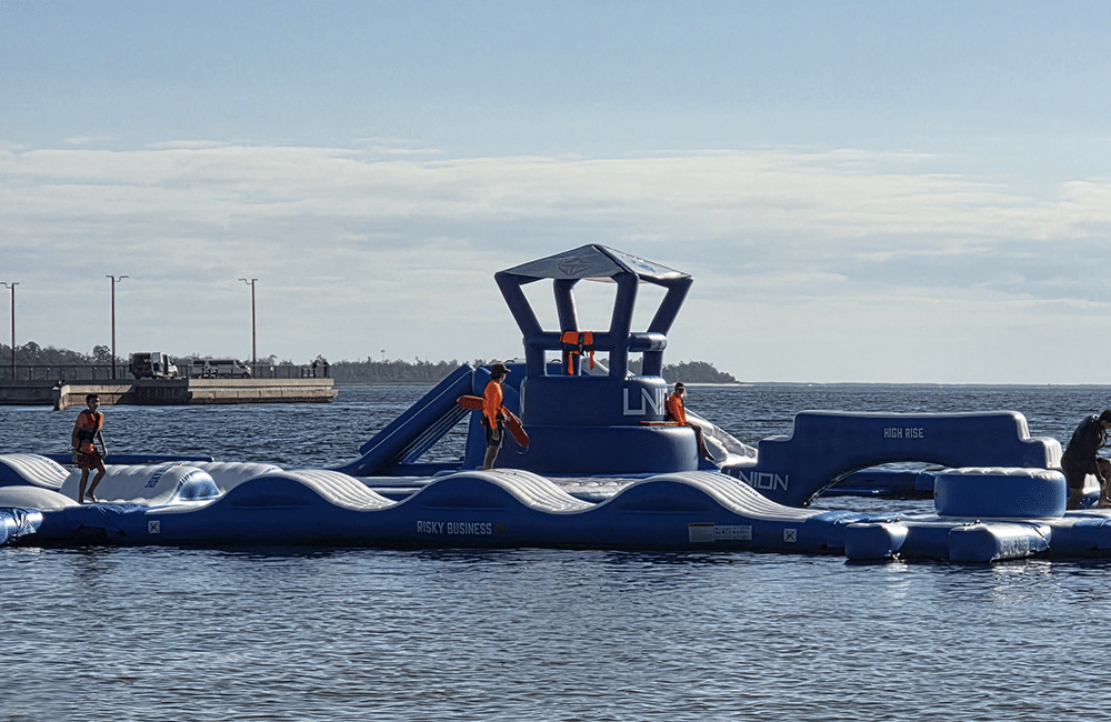Kids playing on an Inflatable obstacle course in St. Andrews Bay - one of the top outdoor activities in Panama City Beach.