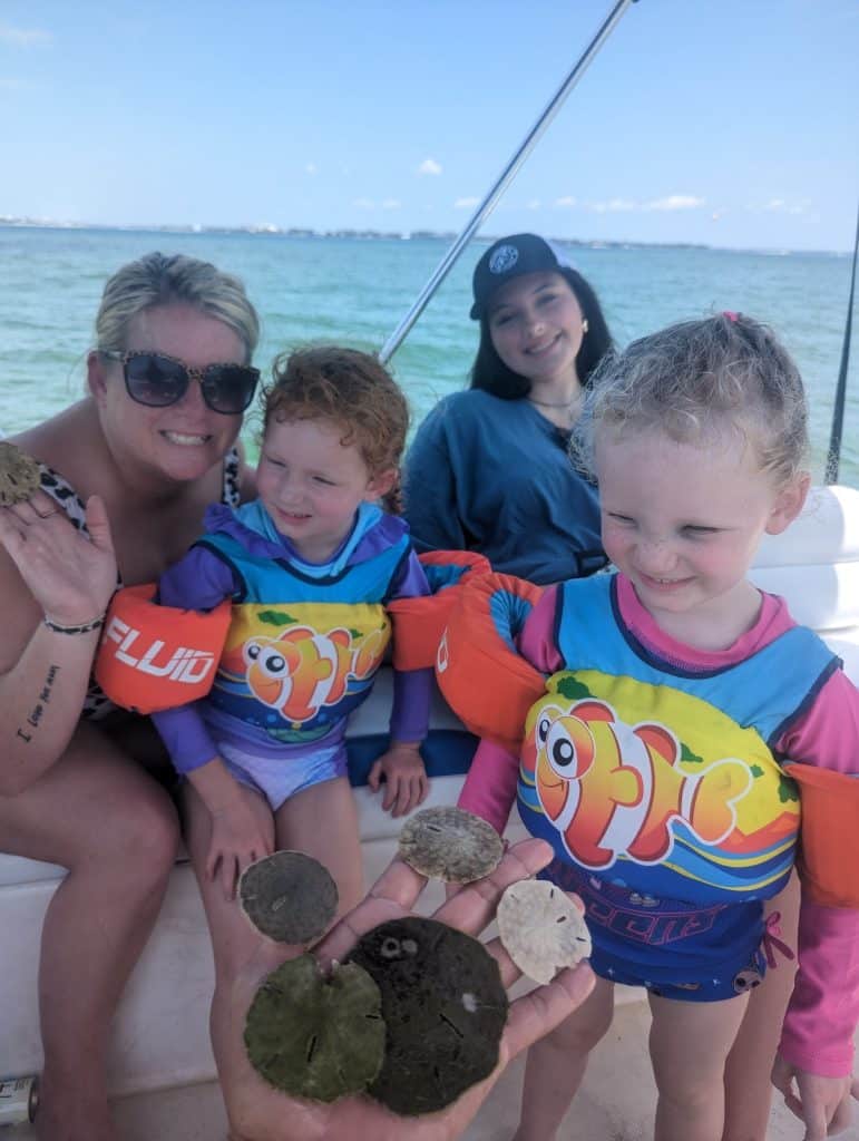 Family discovering live sand dollars during a shell island and dolphin excursion in panama city beach